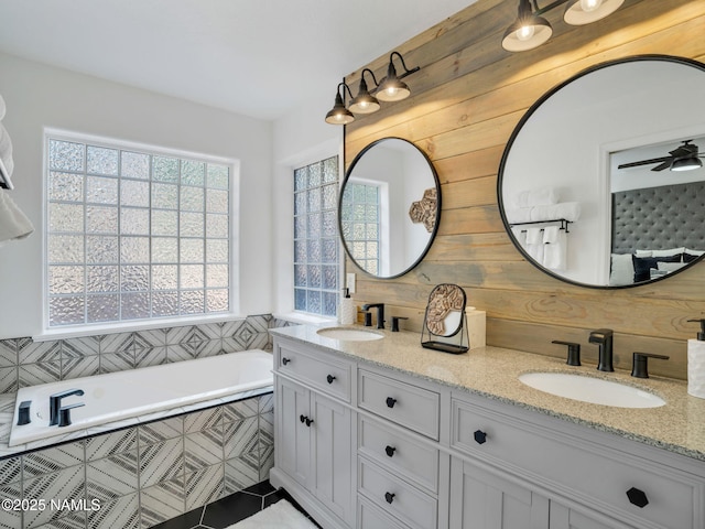 6136 E Abineau Canyon Dr, Flagstaff, AZ 86004 - bathroom featuring plenty of natural light, double vanity, tiled tub, and tile patterned floors