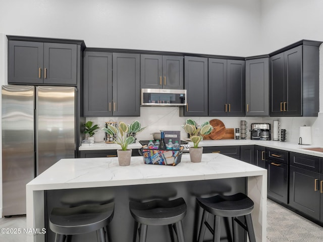6136 E Abineau Canyon Dr, Flagstaff, AZ 86004 - kitchen with stainless steel appliances, a kitchen breakfast bar, light stone countertops, and a center island