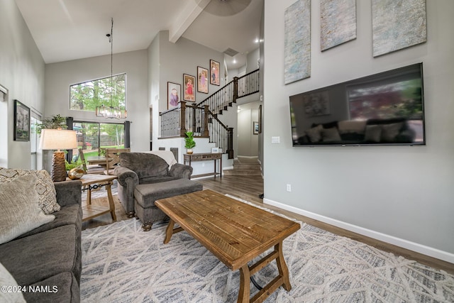 living room featuring high vaulted ceiling, hardwood / wood-style flooring, beamed ceiling, and an inviting chandelier