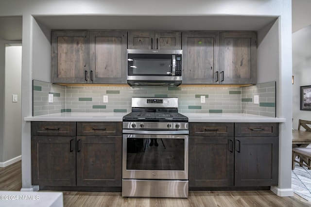 kitchen with backsplash, dark brown cabinetry, and stainless steel appliances