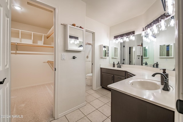 bathroom featuring toilet, vanity, and tile patterned flooring