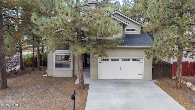 view of property hidden behind natural elements with a garage