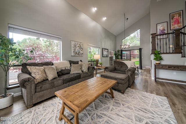 living room featuring high vaulted ceiling, hardwood / wood-style floors, and a chandelier