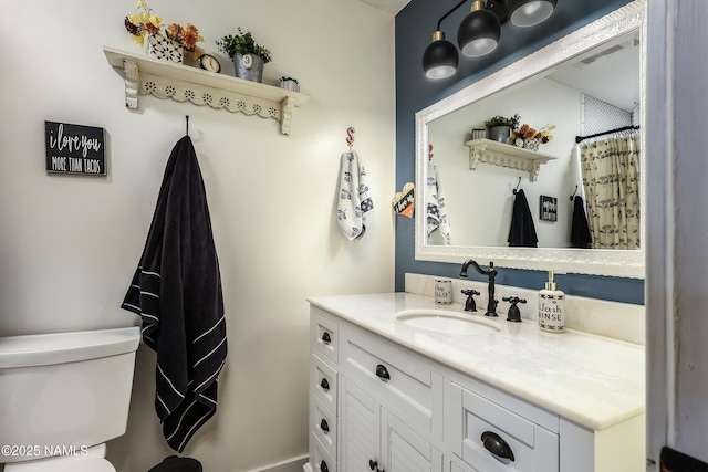 bathroom featuring visible vents, toilet, and vanity