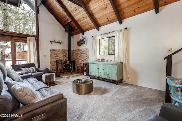 living area with high vaulted ceiling, wood ceiling, a wood stove, and a healthy amount of sunlight