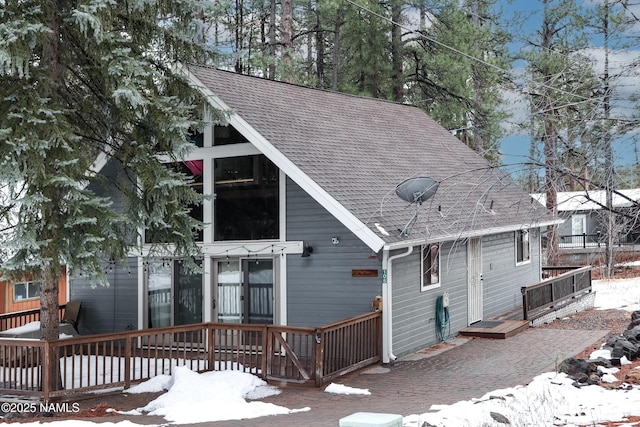 view of front of home featuring a deck and a shingled roof