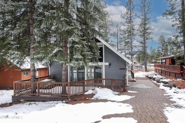 snow covered property featuring a wooden deck