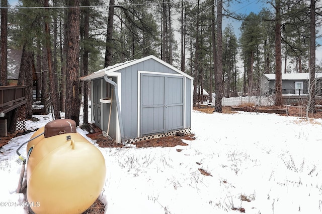 snow covered structure with an outbuilding and a shed