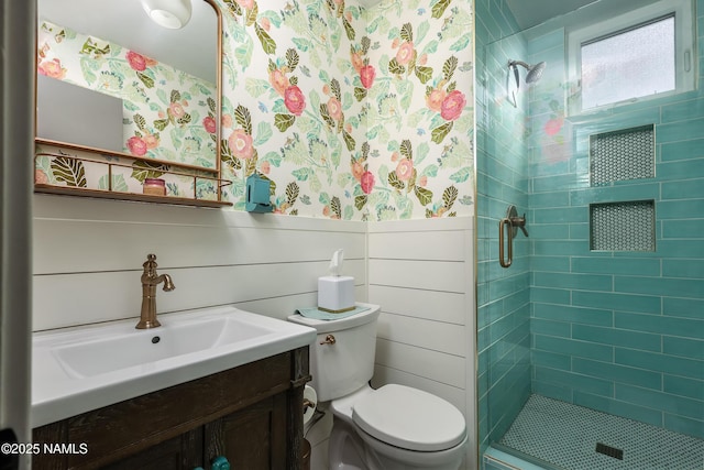 full bath featuring a wainscoted wall, a stall shower, and wallpapered walls