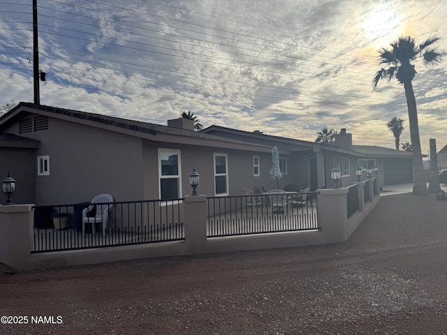 rear view of house with fence and stucco siding