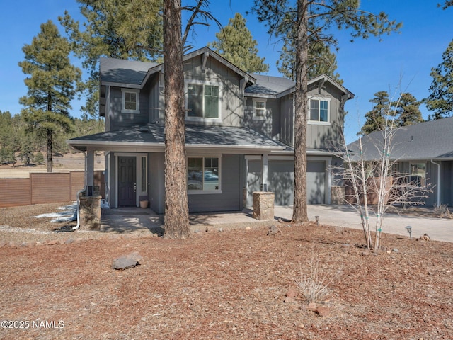 view of front of property with a porch, a garage, fence, driveway, and board and batten siding