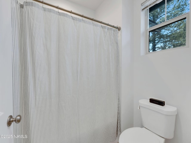 bathroom with toilet and a shower with curtain