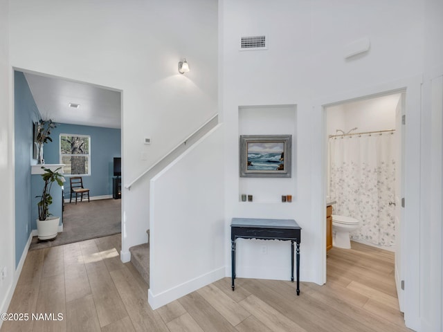 interior space featuring baseboards, visible vents, and wood finished floors