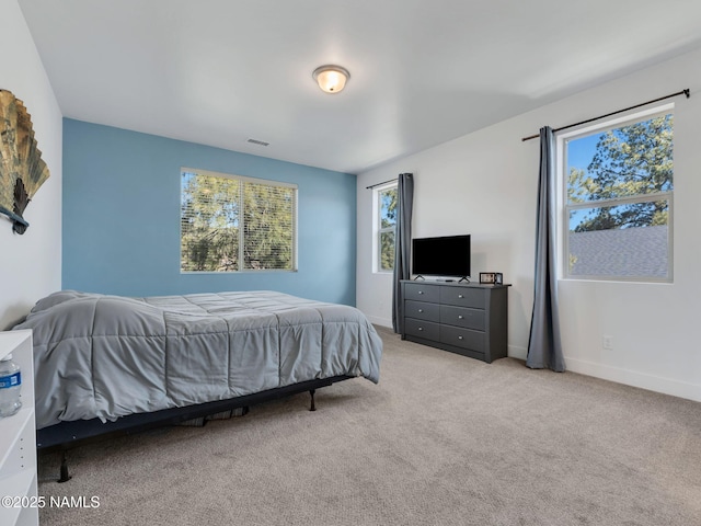 bedroom featuring light carpet, visible vents, and baseboards