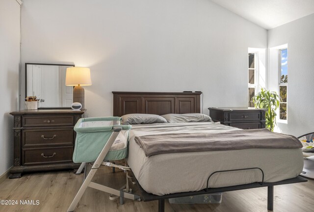 bedroom featuring light hardwood / wood-style flooring and lofted ceiling