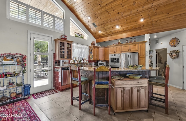 11267 N Lilac Ln, Flagstaff, AZ 86004 - kitchen with stainless steel appliances, high vaulted ceiling, light tile patterned floors, a kitchen bar, and wooden ceiling