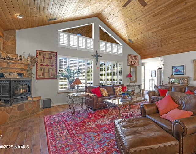 11267 N Lilac Ln, Flagstaff, AZ 86004 - living room with high vaulted ceiling, plenty of natural light, a wood stove, hardwood / wood-style flooring, and a ceiling fan