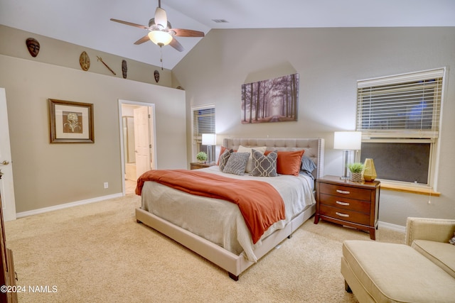 bedroom featuring ceiling fan, ensuite bathroom, light carpet, and lofted ceiling