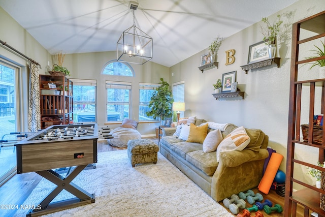 living room featuring vaulted ceiling, a chandelier, hardwood / wood-style floors, and plenty of natural light