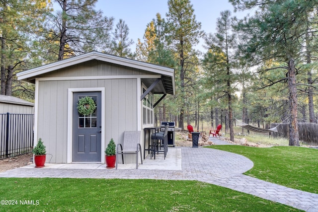 view of outbuilding featuring a lawn and an outdoor bar