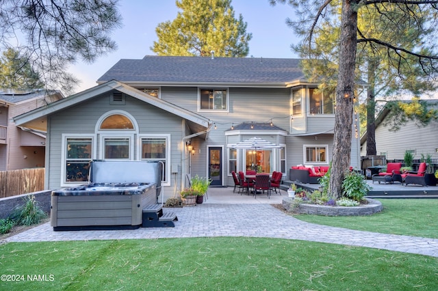 back of property featuring a patio area, a hot tub, an outdoor hangout area, and a yard