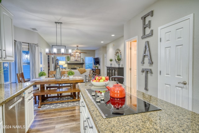 kitchen featuring pendant lighting, white cabinets, and black electric stovetop