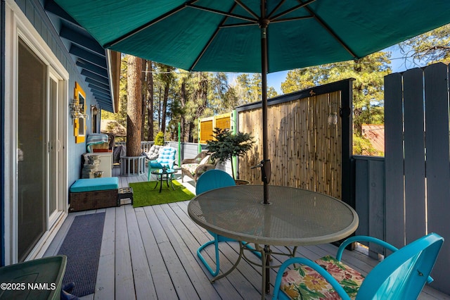 deck with outdoor dining space and fence
