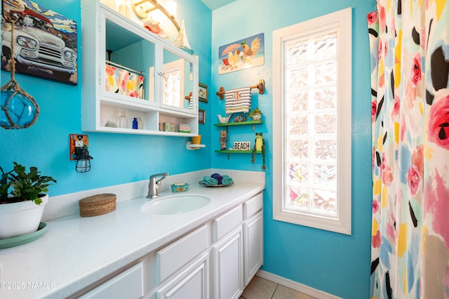 full bathroom with vanity, tile patterned floors, and baseboards