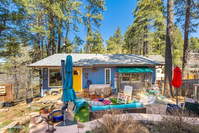 back of house featuring a patio area, a shingled roof, and fence