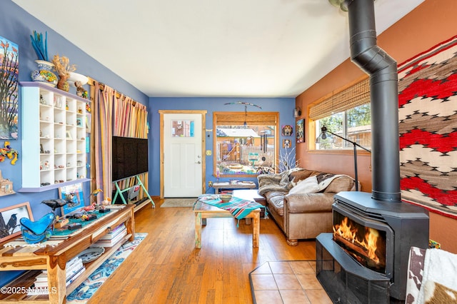 living room with a wood stove and wood finished floors