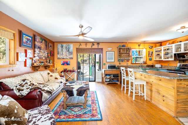 living area with ceiling fan and light wood-style floors