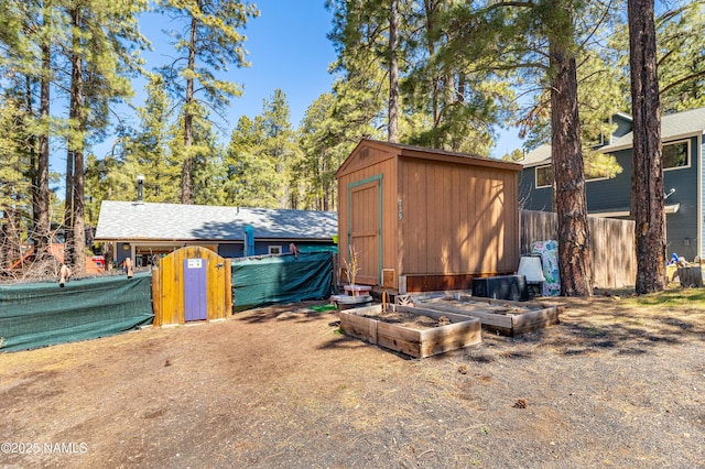 view of shed with a vegetable garden and fence