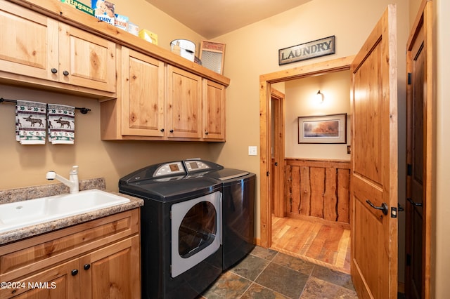 laundry area featuring cabinets, sink, independent washer and dryer, and wooden walls