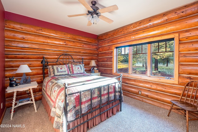 bedroom featuring ceiling fan, rustic walls, and carpet flooring