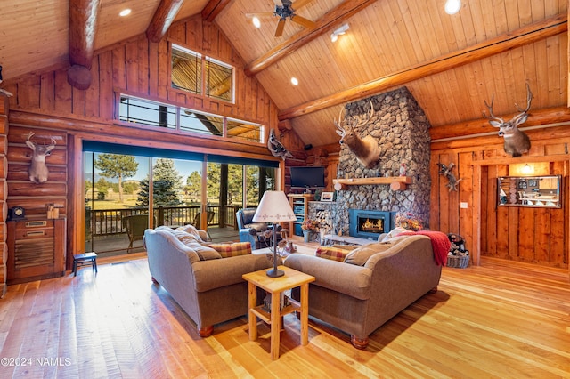 living room featuring a fireplace, light hardwood / wood-style flooring, and high vaulted ceiling