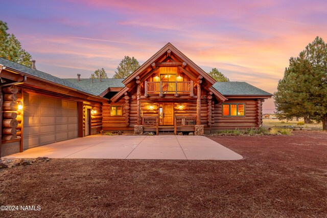 log cabin featuring a balcony and a garage