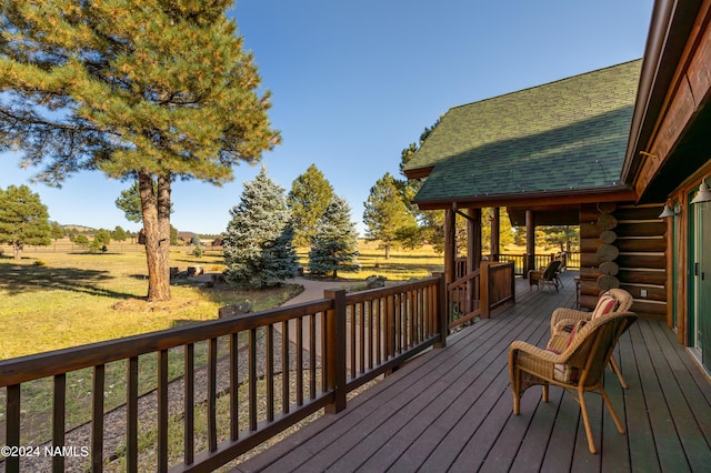 deck with a rural view and a yard