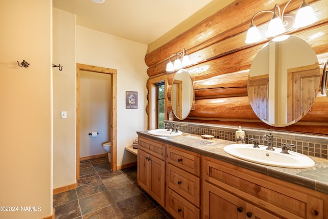 12696 Rustic Cabin Trl, Parks, AZ 86018 - bathroom featuring vanity, backsplash, log walls, and toilet