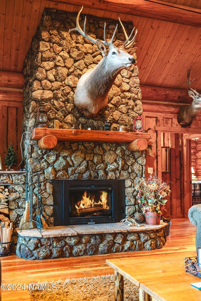 details with a fireplace, beamed ceiling, rustic walls, and wood ceiling