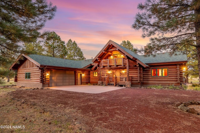 log home featuring a balcony and a garage