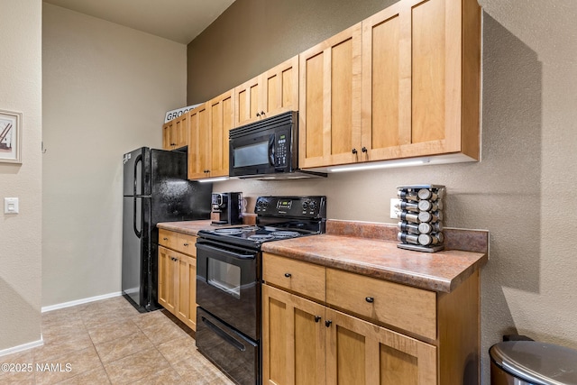 kitchen featuring black appliances, light brown cabinets, light tile patterned floors, and baseboards