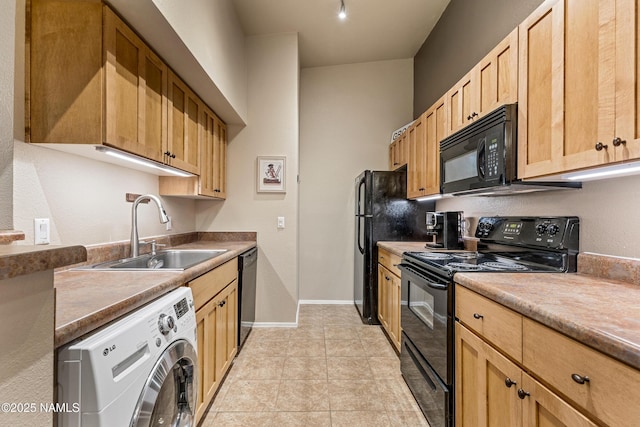 kitchen featuring black appliances, washer / clothes dryer, a sink, baseboards, and light brown cabinets