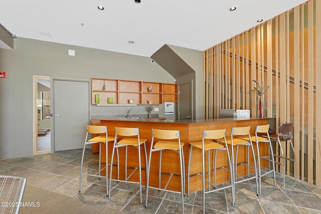 kitchen with open shelves, a sink, a kitchen breakfast bar, and recessed lighting