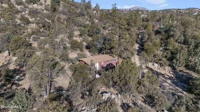 birds eye view of property featuring a forest view and a mountain view