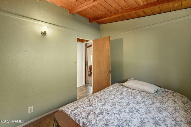 bedroom featuring wooden ceiling, baseboards, and beam ceiling