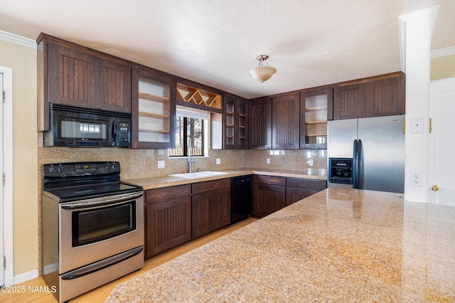 kitchen with a sink, dark brown cabinets, decorative backsplash, black appliances, and glass insert cabinets