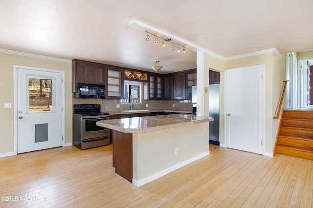 kitchen featuring black microwave, a sink, refrigerator with ice dispenser, stainless steel range with electric cooktop, and decorative backsplash