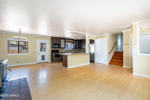 kitchen with appliances with stainless steel finishes, ornamental molding, light wood finished floors, glass insert cabinets, and tasteful backsplash