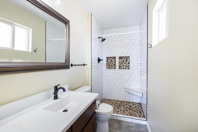 bathroom with toilet, a stall shower, tile patterned flooring, and vanity