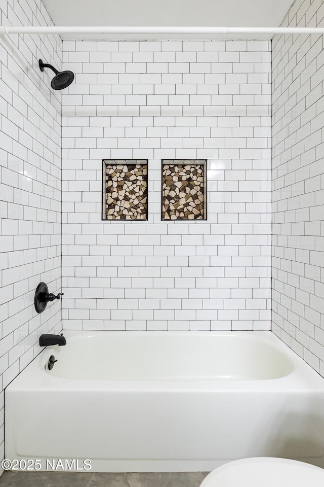 bathroom featuring bathtub / shower combination and toilet